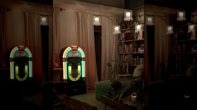 An eclectic living room at night with a lit jukebox