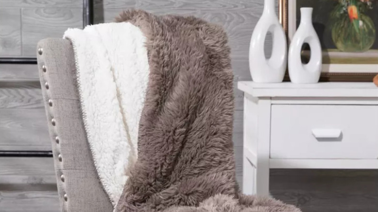 A fluffy gray and white blanket over a chair