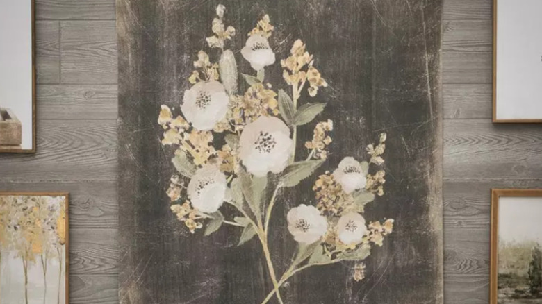 Gray canvas wall hanging with white and yellow flowers on it