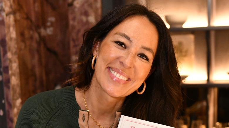 Joanna Gaines smiling in a warmly decorated room
