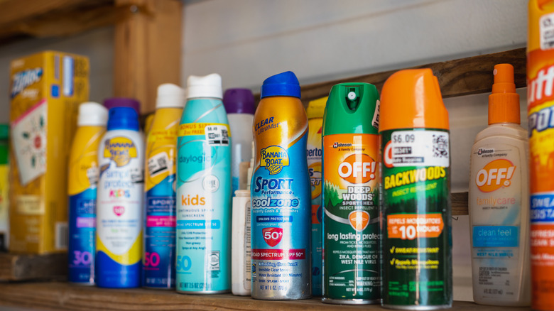 Cans of sunscreen and bug spray on a shelf
