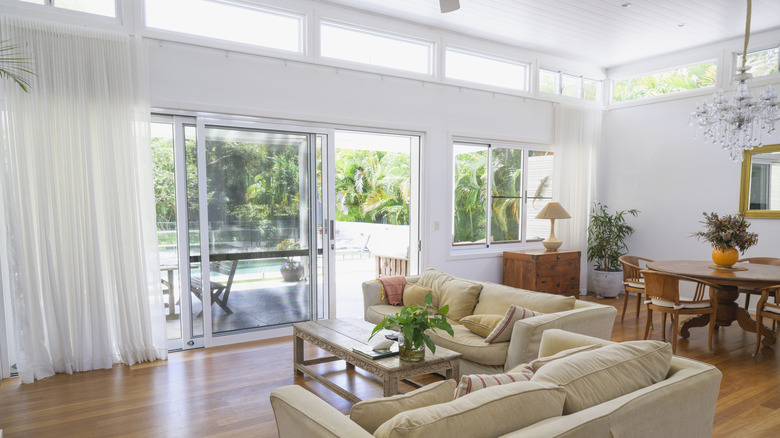 Sheer, white curtains hanging high above sliding glass doors.