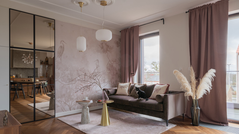 A large room decorated in dusty pink accents and curtains around each door.