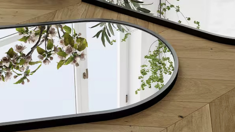 Simple arched black wall mirror waiting to be hung up