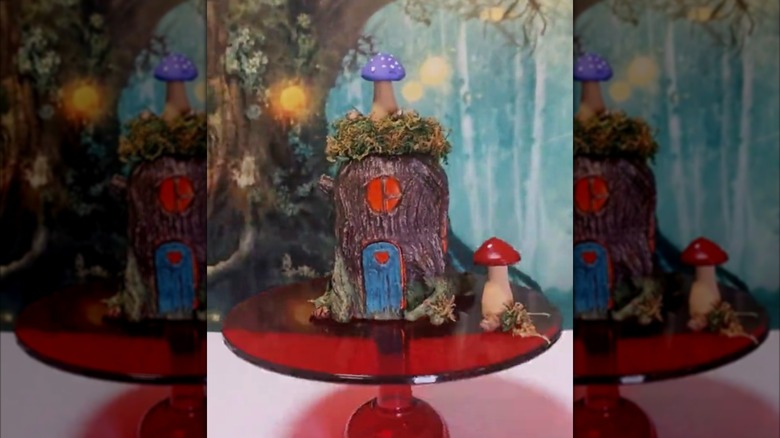 DIY fairy house made of a mason jar with moss and a mushroom on the lid