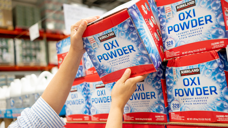 Hand picking out a box of laundry Costco's Kirkland detergent
