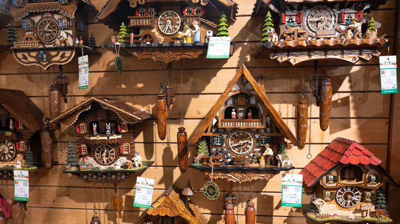 Cuckoo clocks on a wooden wall with sales tags hanging from them