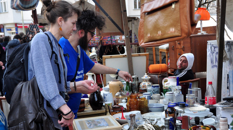 Two people shopping for antiques at a market