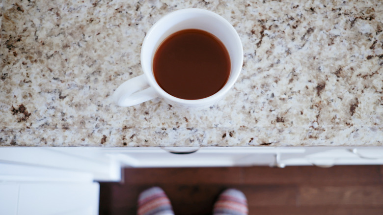 Coffee cup sitting on brown granite countertop