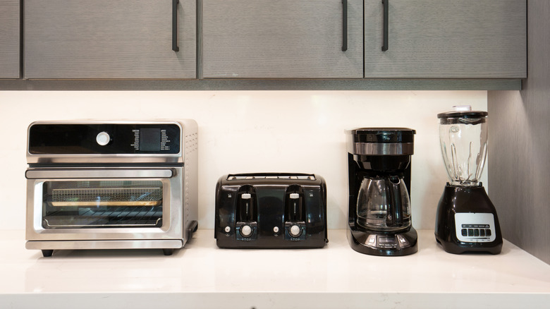 A toaster oven, toaster, coffee maker, and blender
