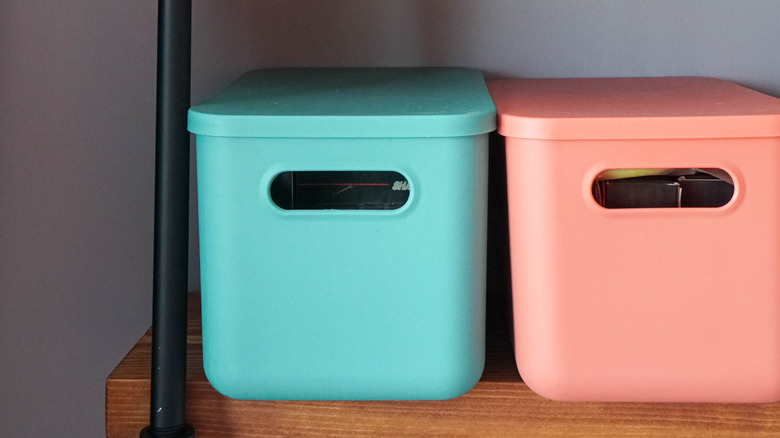 Two colored storage boxes on a shelf
