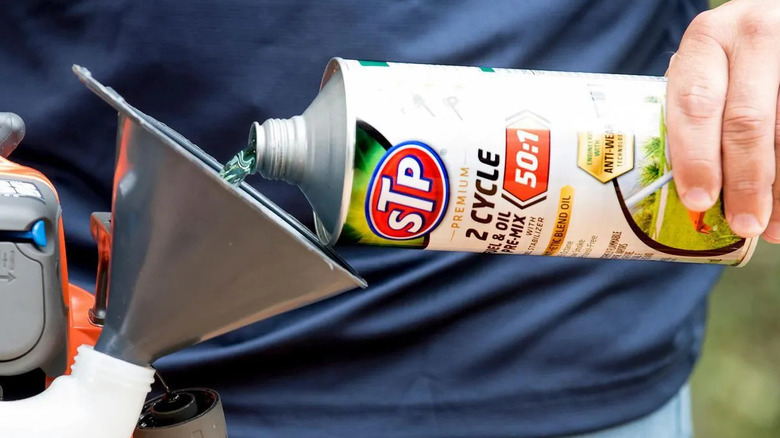 Pouring oil/fuel pre-mix into a two-cycle engine