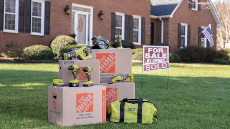 Ryobi Tools arranged on boxes in front of home for sale