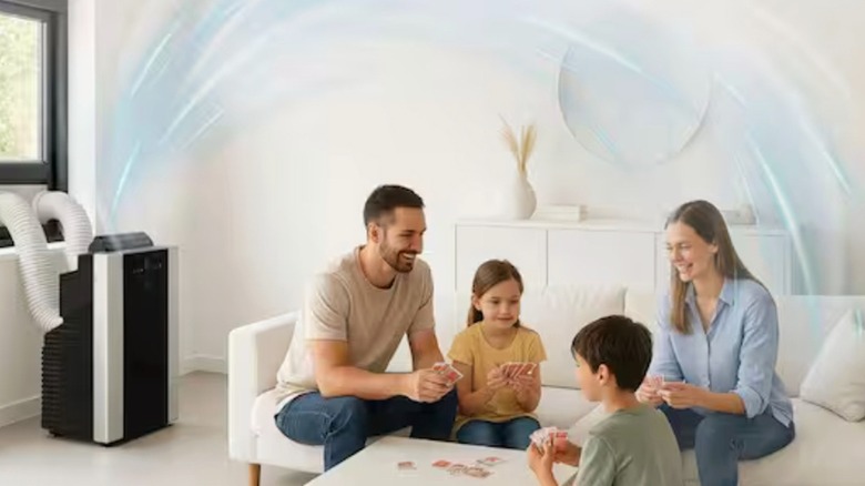 Family playing cards with portable air conditioner cooling the room