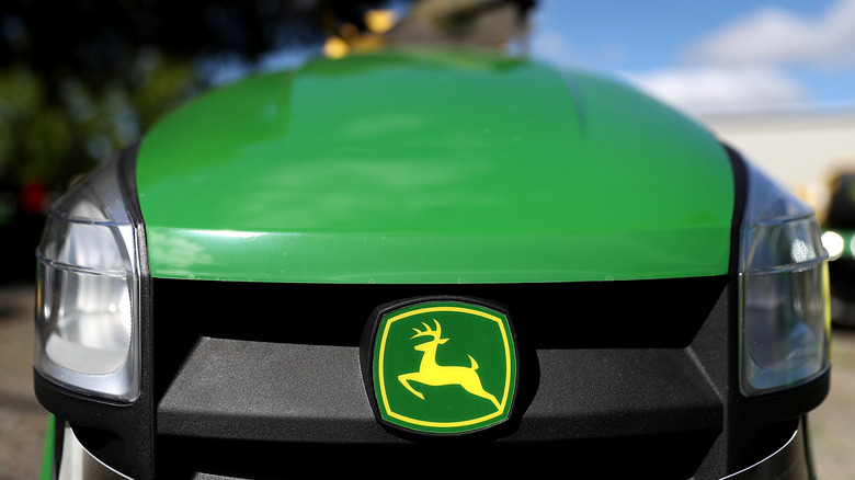 The engine cover and headlights of a John Deere lawn tractor