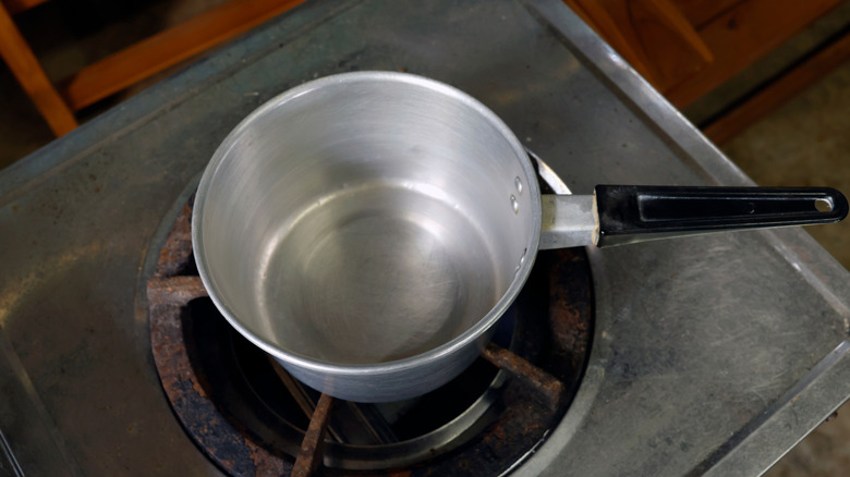 Empty aluminum pot sitting on a stove