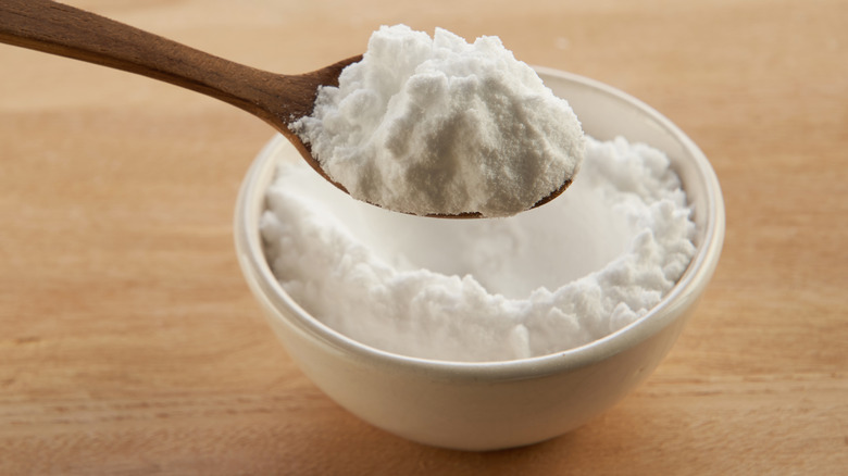Bowl of baking soda with wooden spoon