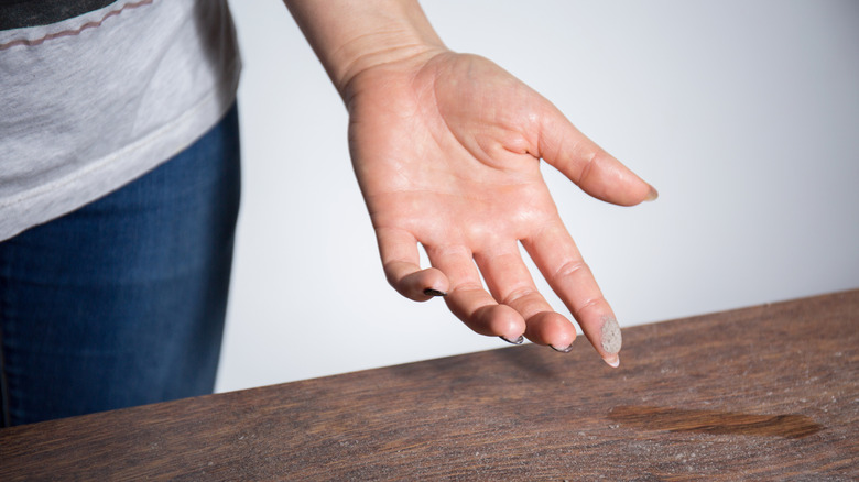Woman with dust on her finger after touching surface