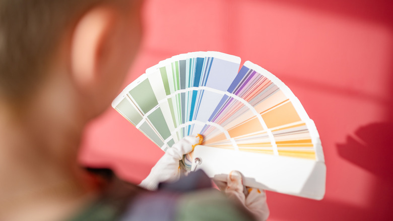 A person looks through paint color samples