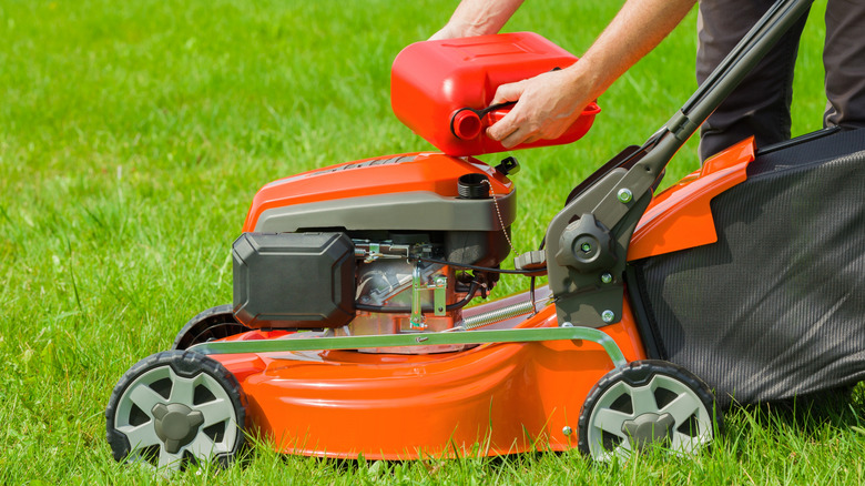 Homeowner fueling a lawn mower