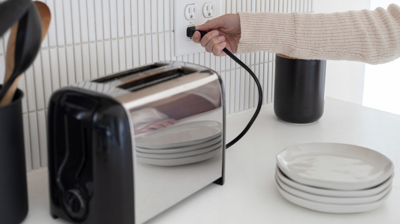 Person unplugging toaster