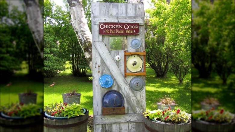 A door in a garden decorated with pot lids