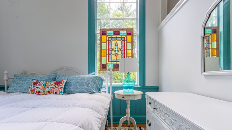 bedroom with decorative stained glass window and blue glass lamp
