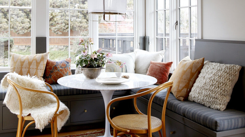 white kitchen with gray linen window bench and small table