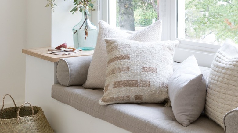 white nook with window bench seating with pullows