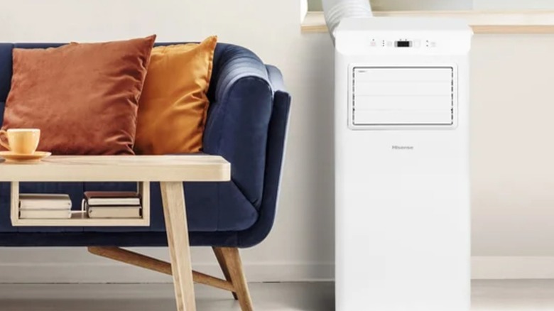 A portable Hisense air conditioner in use next to a couch and coffee table