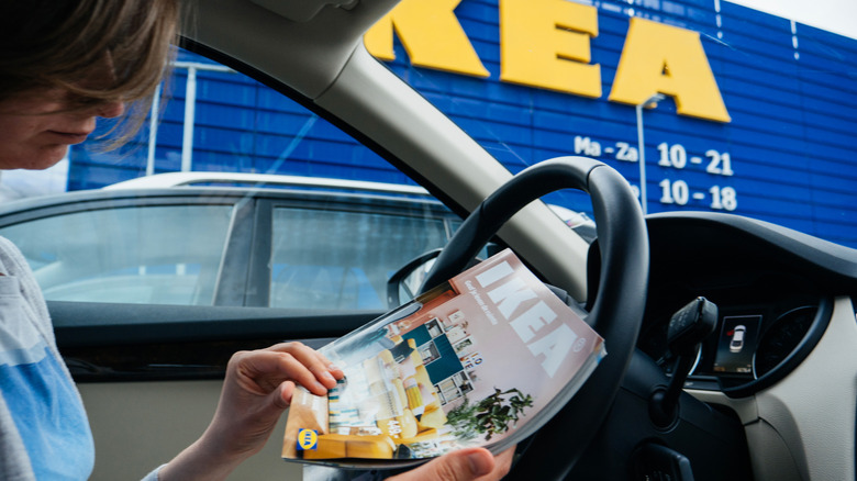 Person stopped outside of IKEA looking at catalog.