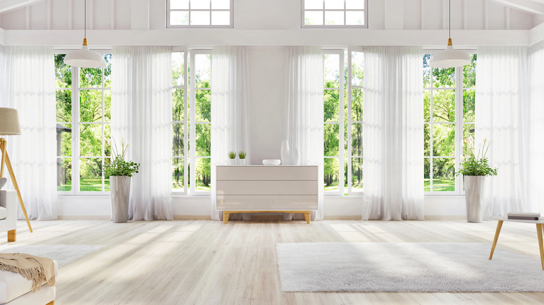 A mostly white minimalist room with multiple boring white sheer curtains