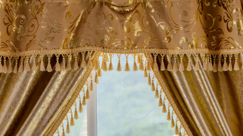 Ornate golden curtains with valence and tassels