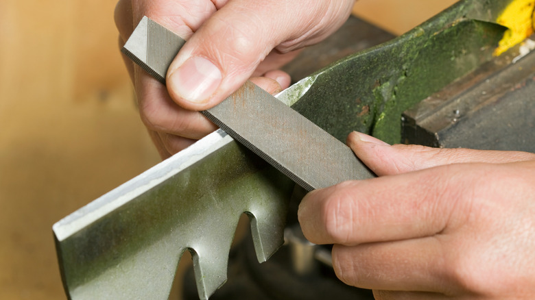 Sharpening a lawn mower blade with a traditional file