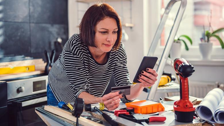 A woman pausing a project to shop for tools online