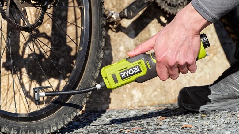 Man using Ryobi USB Lithium Bike and Ball Pump on bike tire