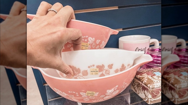 a person inspects Pyrex Pink Gooseberry Cinderella Mixing Bowls