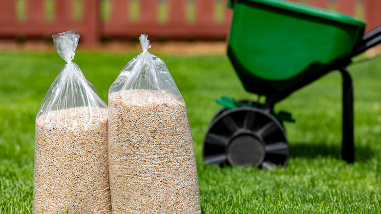 Herbicide and fertilizer granules alongside a spreader
