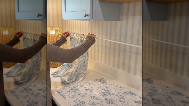 hands holding napkins on curtain rod