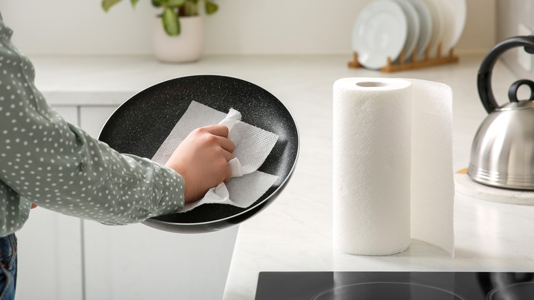 Person using paper towels from a roll that's sitting on the countertop