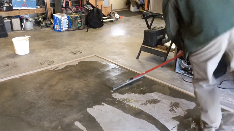 Man testing his garage floor dam