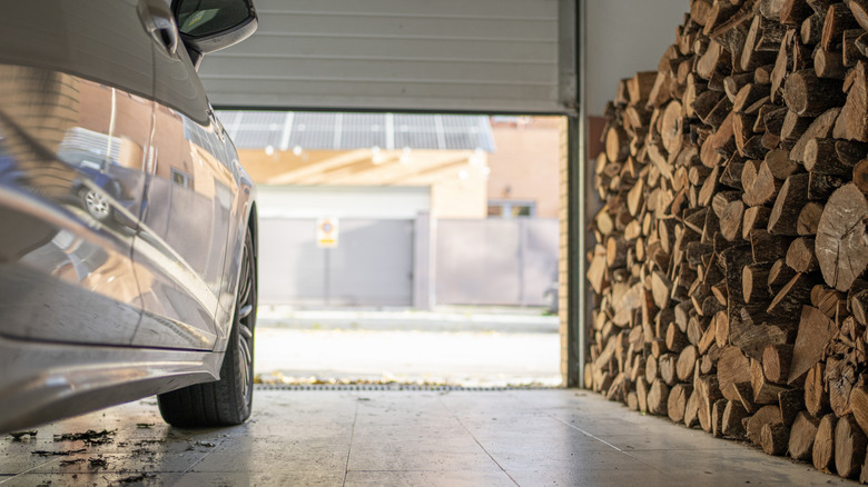 Garage floor with grime in winter next to firewood