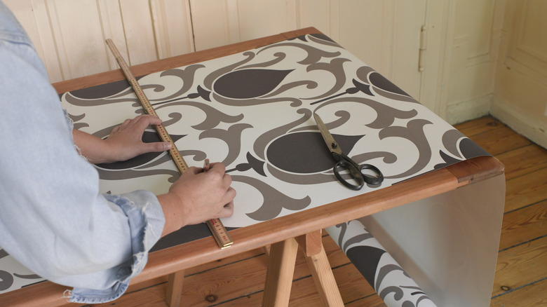 Rolls of stylish contact paper on a wood table.