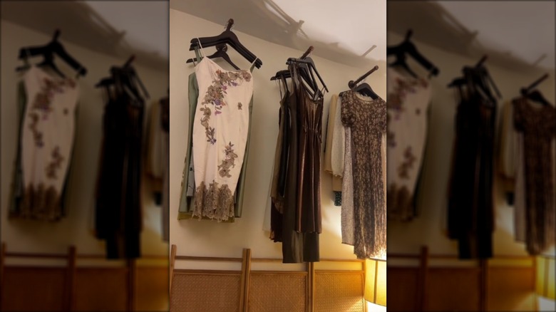 Dresses hanging above a rattan bed frame