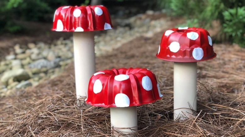 3 bundt pan mushrooms on pvc pipe stems in a garden