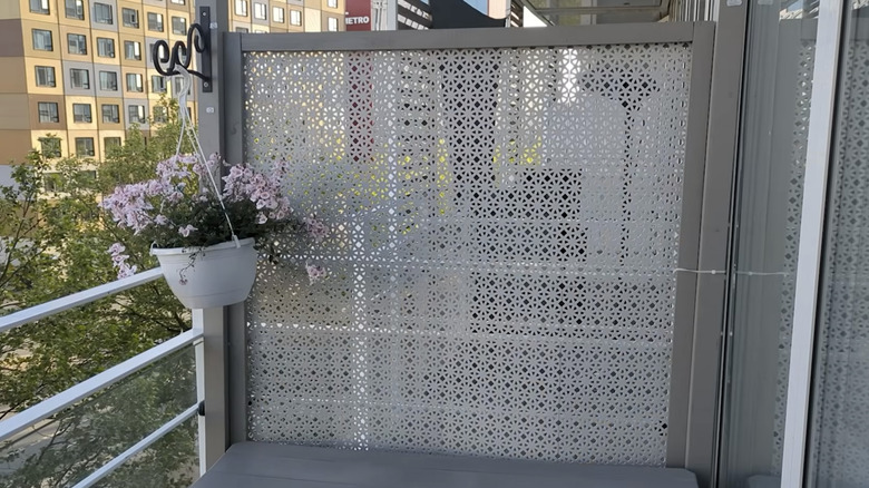 A balcony privacy screen made with IKEA ALTAPPEN perforated decking tiles inside a painted wood frame