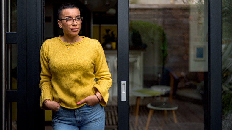 Woman standing by her glass front door