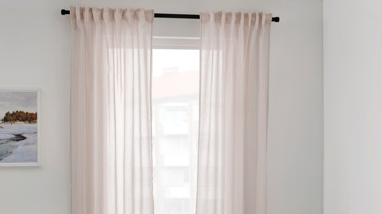 Sheer beige and white striped IKEA BYMOTT curtains in a window