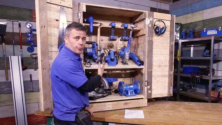 A DIY worker showing off tool storage made from pallet wood