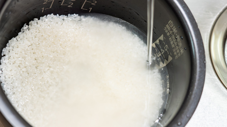 White rice being rinsed with water